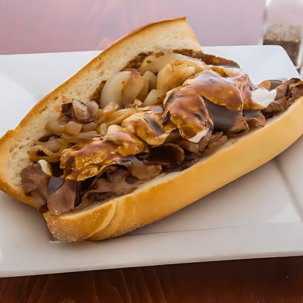 John's Deli cheesesteak with steak, onions, and gravy on a hoagie roll.