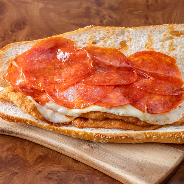A John's Deli pepperoni and cheese sandwich on a wooden cutting board.