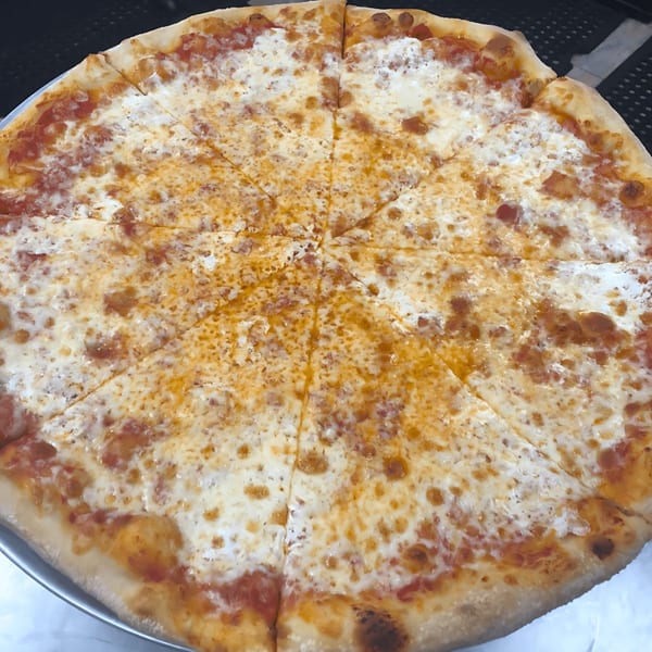 A large, freshly baked cheese pizza from John's Deli, cut into many slices.